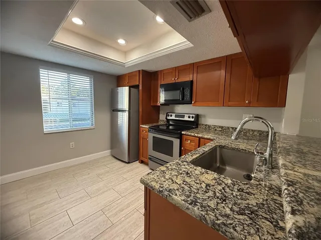 a kitchen with stainless steel appliances granite countertop a sink stove and refrigerator