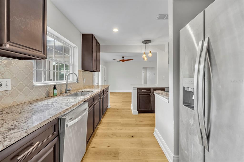 4234 Kendrick Road Orlando, FL 32804 - Photo 17 of 46 a kitchen with stainless steel appliances granite countertop a refrigerator and a sink