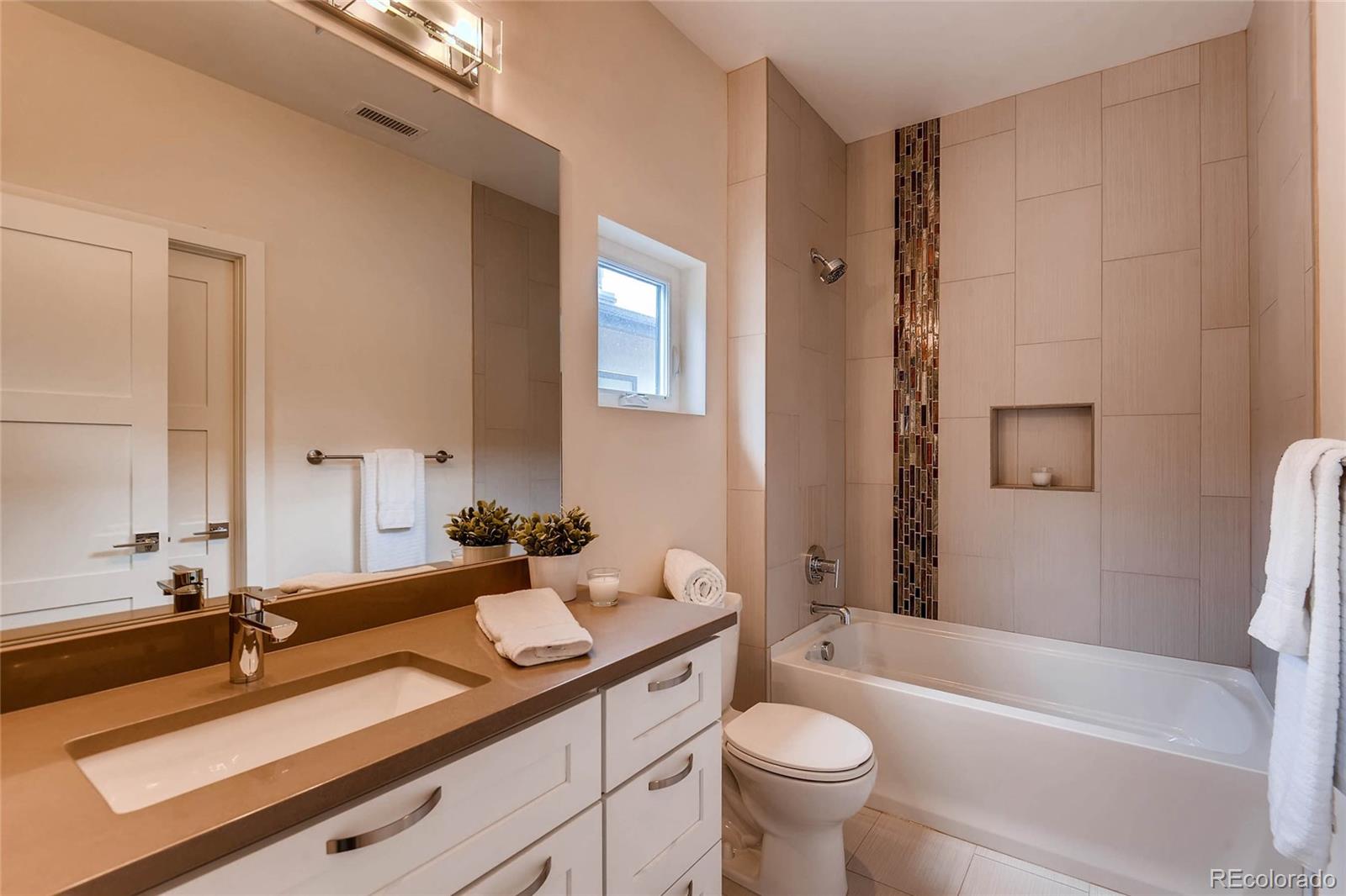 3957 Utica Street Denver, CO 80212 - Photo 14 of 28 a bathroom with a double vanity sink toilet mirror and bathtub