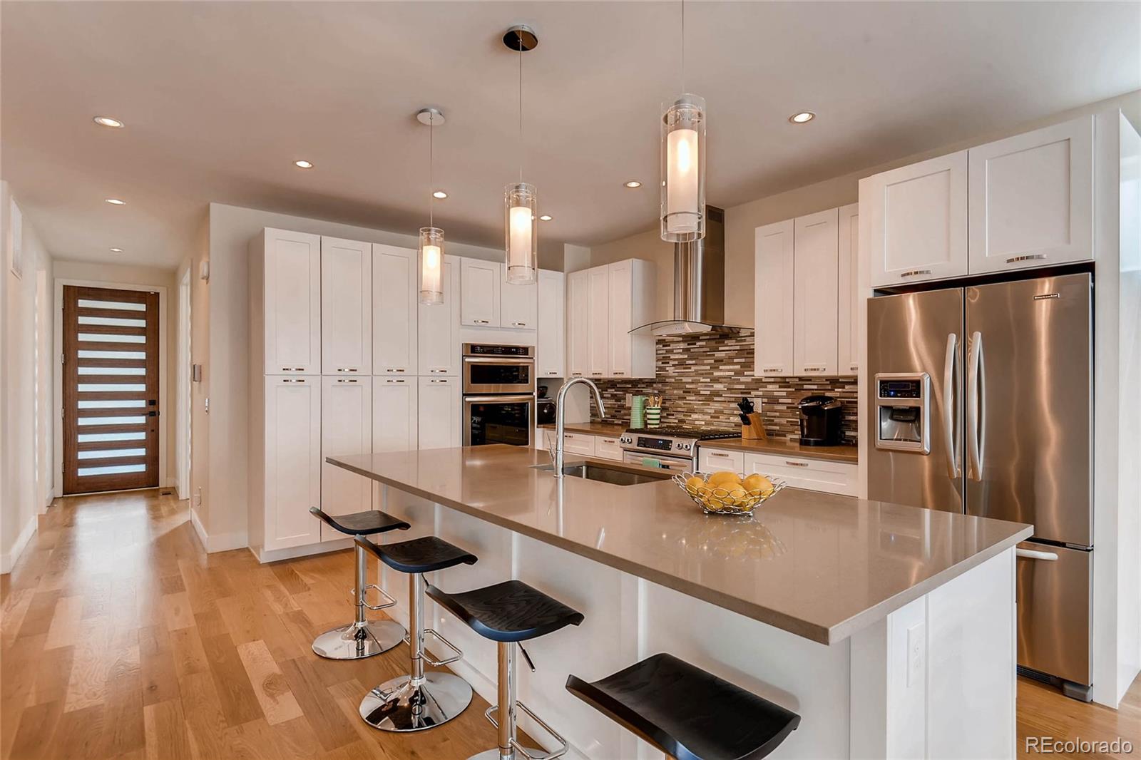 3957 Utica Street Denver, CO 80212 - Photo 7 of 28 a kitchen with stainless steel appliances granite countertop a sink refrigerator and cabinets