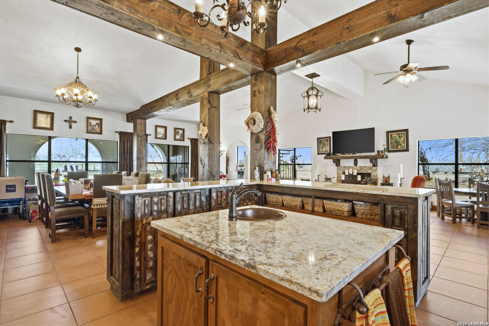 1150 Bruce Road Poteet, TX 78065 - Photo 15 of 33 a kitchen with a stove a sink dishwasher and a dining table with wooden floor