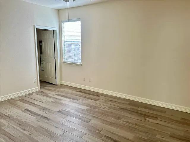 an empty room with wooden floor and a window