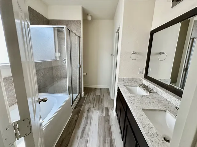 a bathroom with a granite countertop sink a mirror and shower