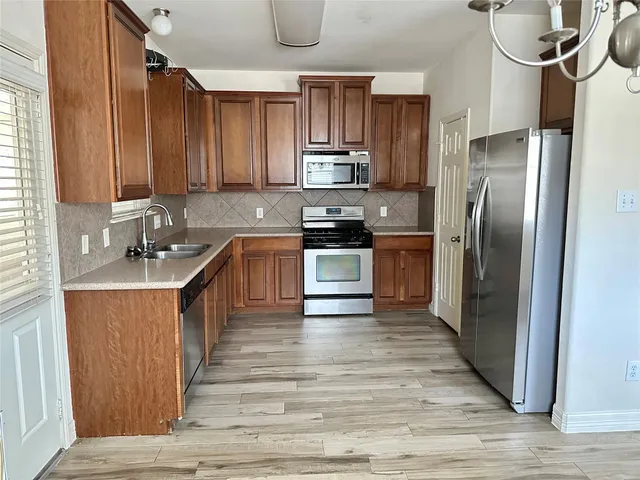 a kitchen with stainless steel appliances granite countertop a stove a refrigerator and a sink