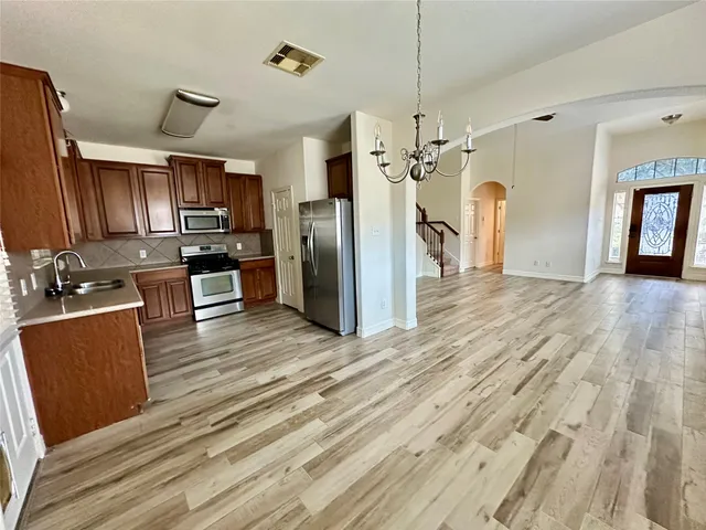 a open kitchen with refrigerator stove microwave and cabinets