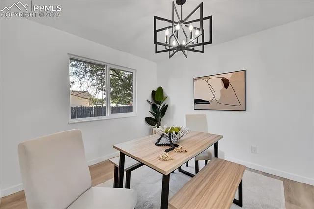 a view of a dining room with furniture a chandelier and wooden floor