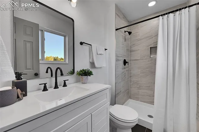 a bathroom with a sink a toilet and shower