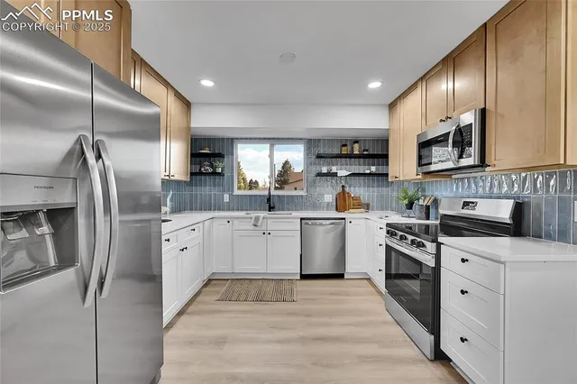 a kitchen with granite countertop a refrigerator stove top oven and sink