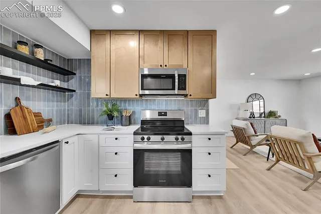a kitchen with granite countertop a stove top oven and cabinets