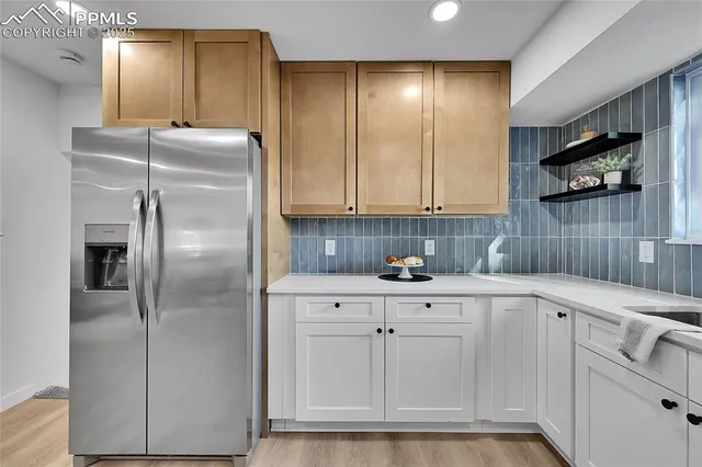 a kitchen with white cabinets and refrigerator