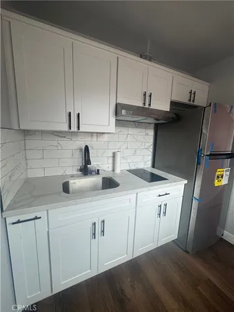 a kitchen with stainless steel appliances a sink a refrigerator and cabinets