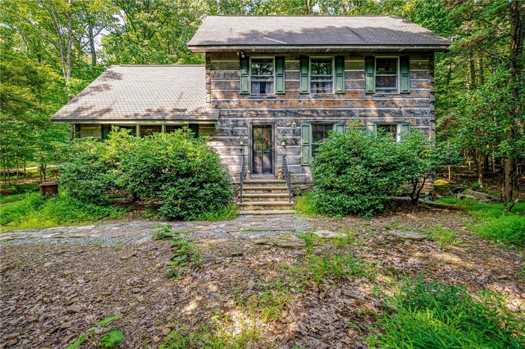183 Chestnut Ridge Road Acme, PA 15610 - Photo 2 of 29 a backyard of a house with plants and outdoor seating