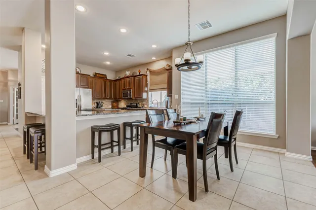 a view of a dining room and livingroom with furniture wooden floor a chandelier