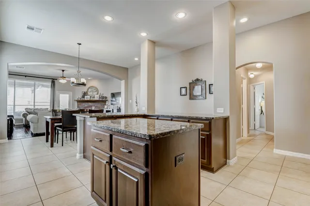 a kitchen with kitchen island granite countertop a sink cabinets and stainless steel appliances
