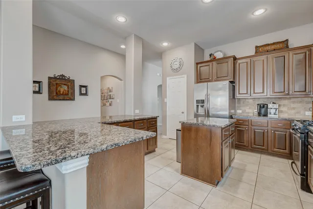 a kitchen with stainless steel appliances granite countertop a refrigerator oven a sink and dishwasher