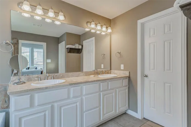 a bathroom with a double vanity sink and a mirror