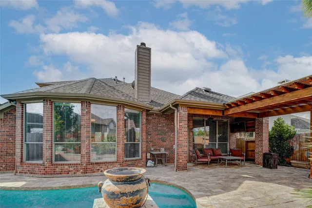 a patio with a table and chairs and potted plants