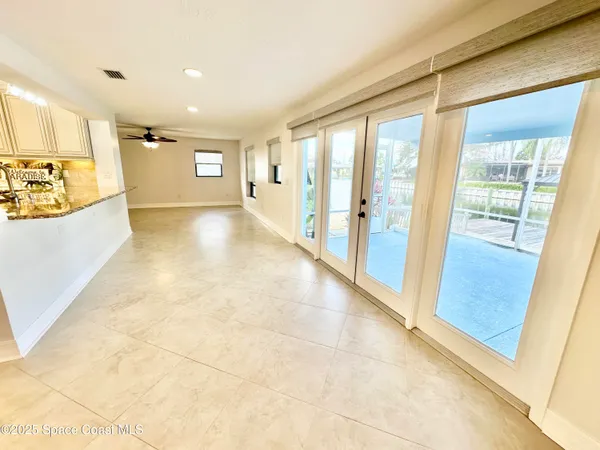 an empty room with windows and fan