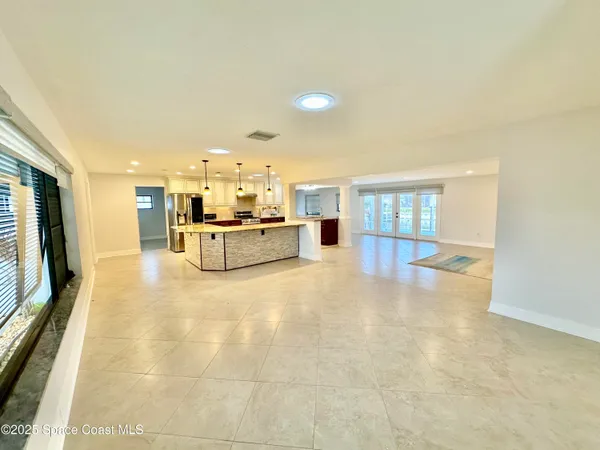 a large kitchen with kitchen island a large counter top a sink a stove and refrigerator