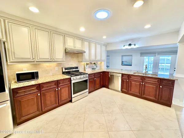 a kitchen with stainless steel appliances granite countertop a sink and cabinets