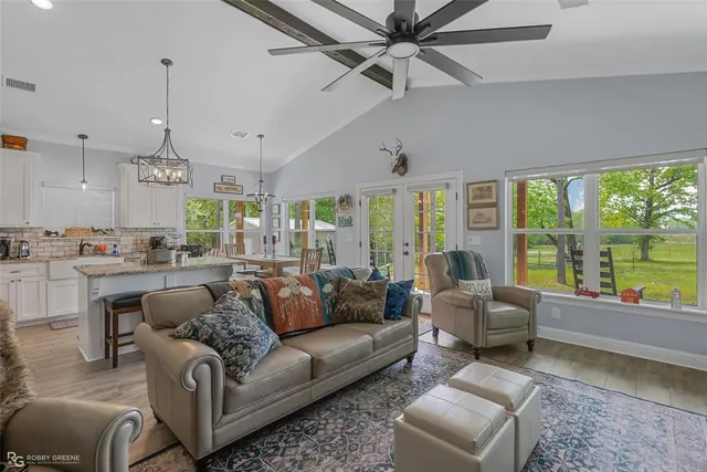 a living room with furniture and a large window with kitchen view