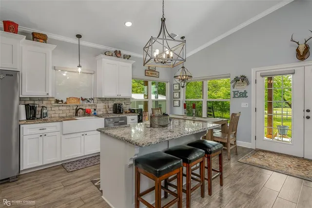 a kitchen with kitchen island granite countertop a sink a center island and cabinets