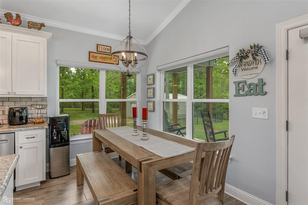 260 Circle M Road Benton, LA 71006 - Photo 15 of 30 a view of a dining room with furniture large windows and wooden floor