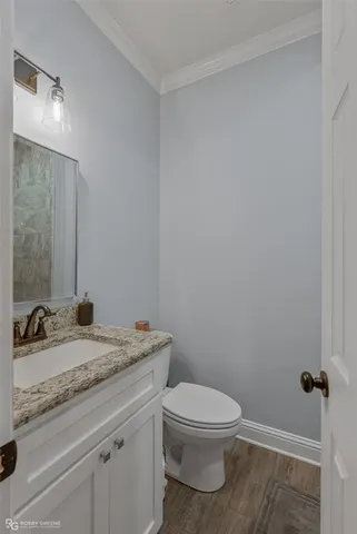 a bathroom with a granite countertop toilet a sink and a mirror
