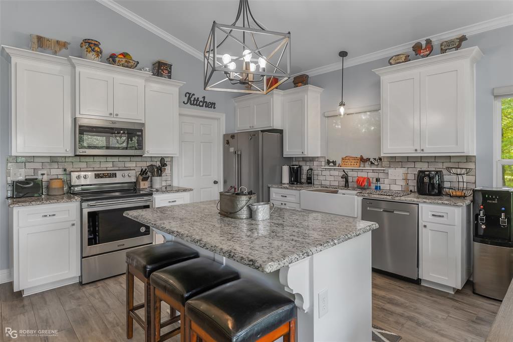 260 Circle M Road Benton, LA 71006 - Photo 18 of 35 a kitchen with stainless steel appliances granite countertop a kitchen island hardwood floor sink stove and microwave
