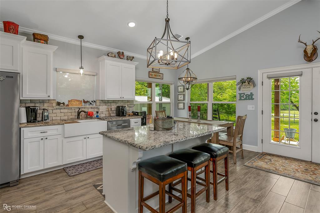 260 Circle M Road Benton, LA 71006 - Photo 19 of 35 a kitchen with kitchen island granite countertop a sink a center island and cabinets