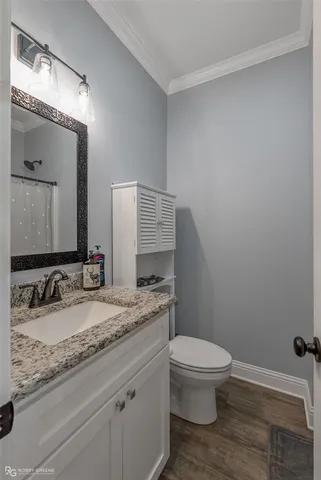 a bathroom with a granite countertop toilet sink and mirror