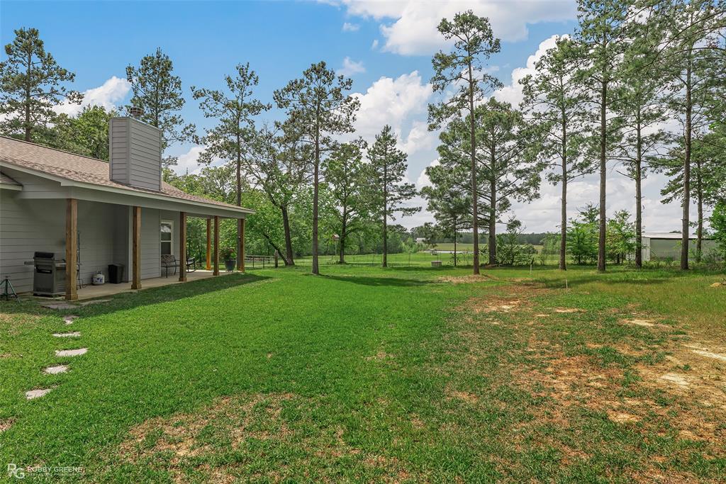 260 Circle M Road Benton, LA 71006 - Photo 29 of 35 a view of a house with a big yard and palm trees