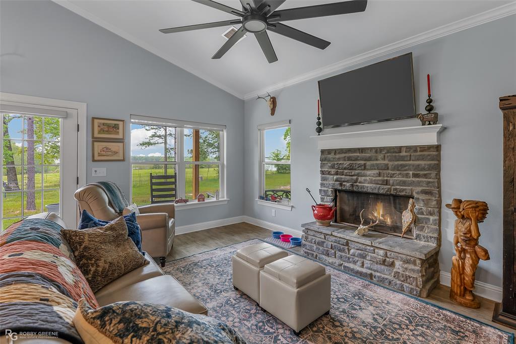 260 Circle M Road Benton, LA 71006 - Photo 10 of 30 a living room with furniture a flat screen tv and a fireplace