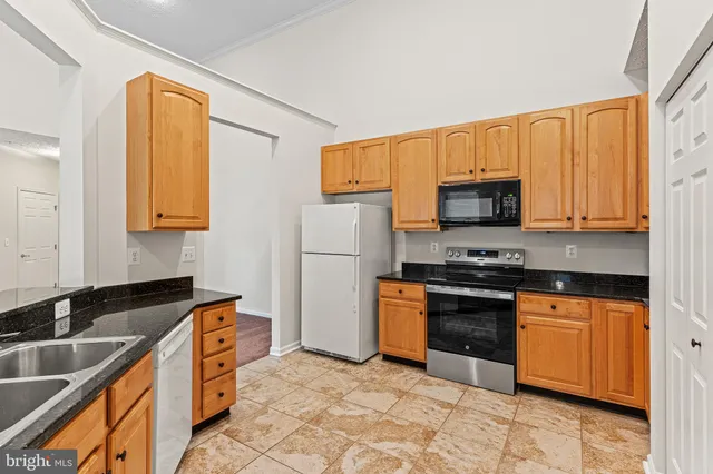 a kitchen with stainless steel appliances granite countertop a stove a sink dishwasher and a refrigerator