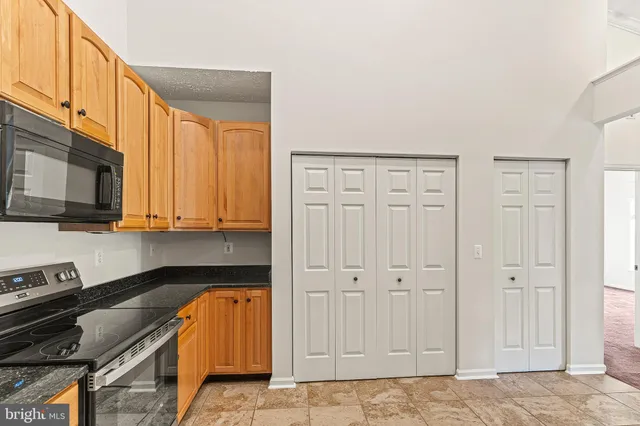 a kitchen with stainless steel appliances granite countertop a refrigerator a stove top oven a sink and dishwasher