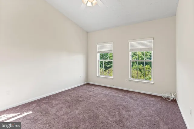 an empty room with a ceiling fan and a window