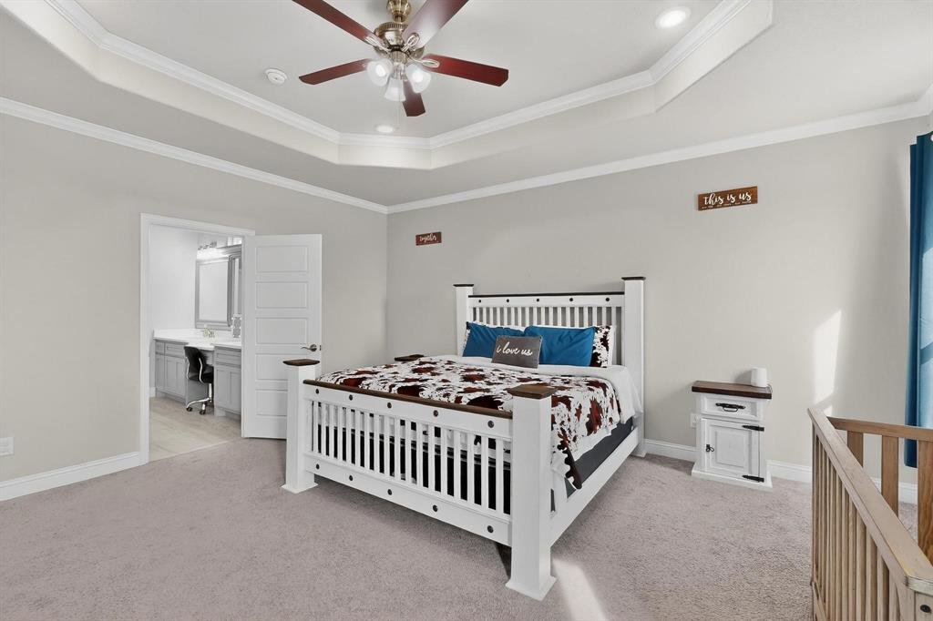 129 Altom Road Springtown, TX 76082 - Photo 16 of 40 a bedroom with a bed and a chandelier