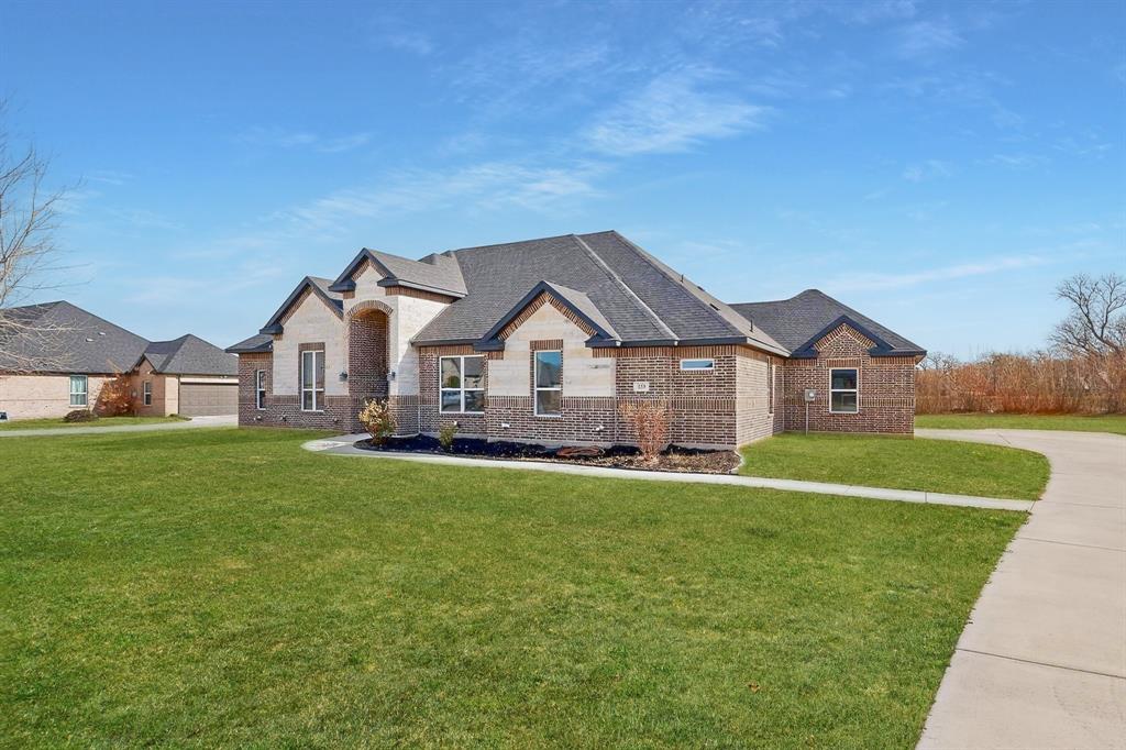 129 Altom Road Springtown, TX 76082 - Photo 2 of 40 a front view of a house with a yard and garage