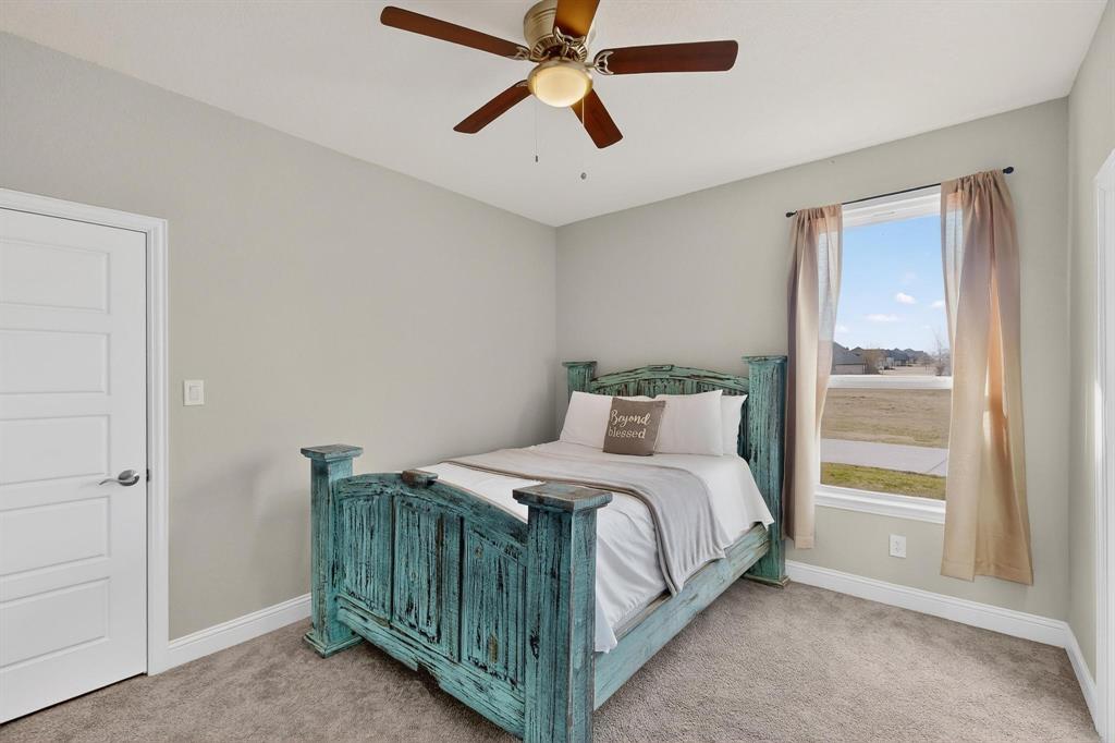 129 Altom Road Springtown, TX 76082 - Photo 34 of 40 a bedroom with a bed and a chandelier fan