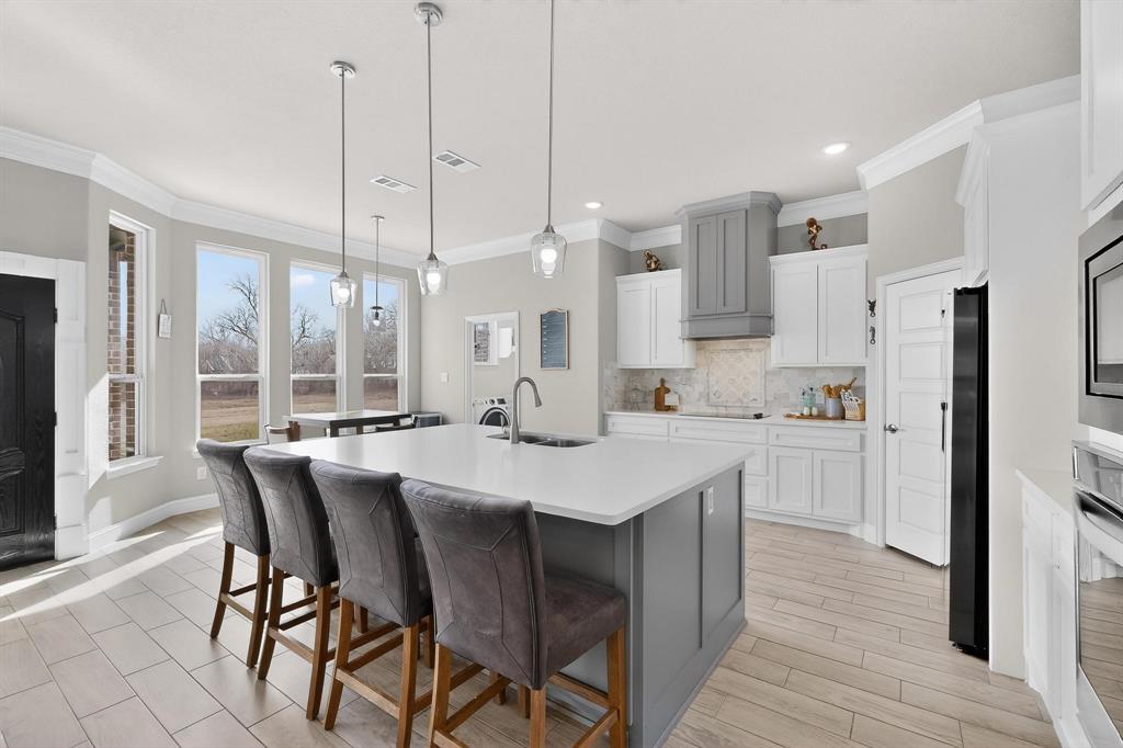129 Altom Road Springtown, TX 76082 - Photo 10 of 40 a large kitchen with kitchen island a dining table and chairs