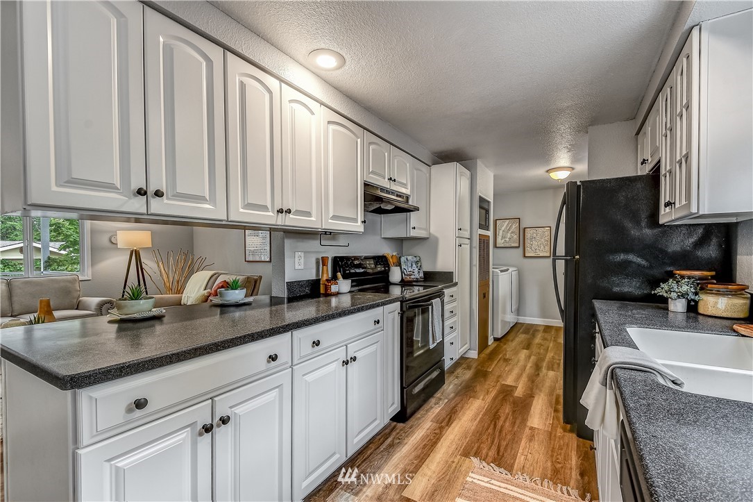 12723 Northeast 199th Street Bothell, WA 98011 - Photo 11 of 34 a kitchen with granite countertop a sink a stove and refrigerator
