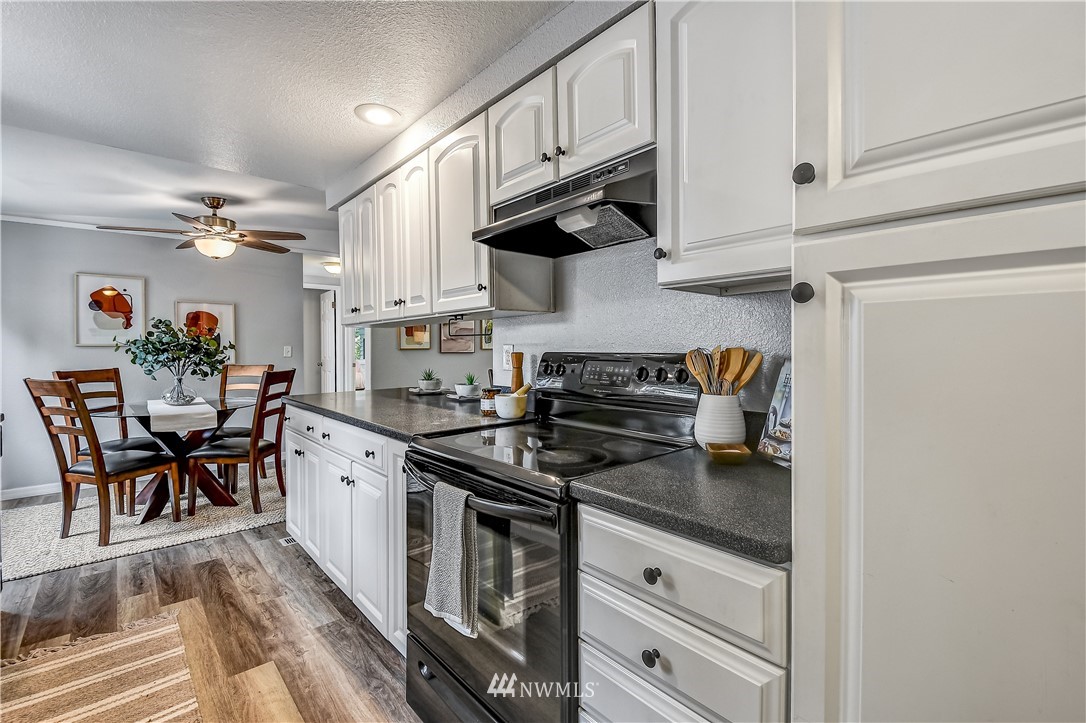 12723 Northeast 199th Street Bothell, WA 98011 - Photo 12 of 34 a kitchen with stainless steel appliances granite countertop a stove and a sink
