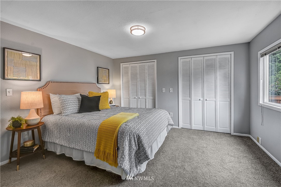 12723 Northeast 199th Street Bothell, WA 98011 - Photo 17 of 34 a spacious bedroom with a bed and a window