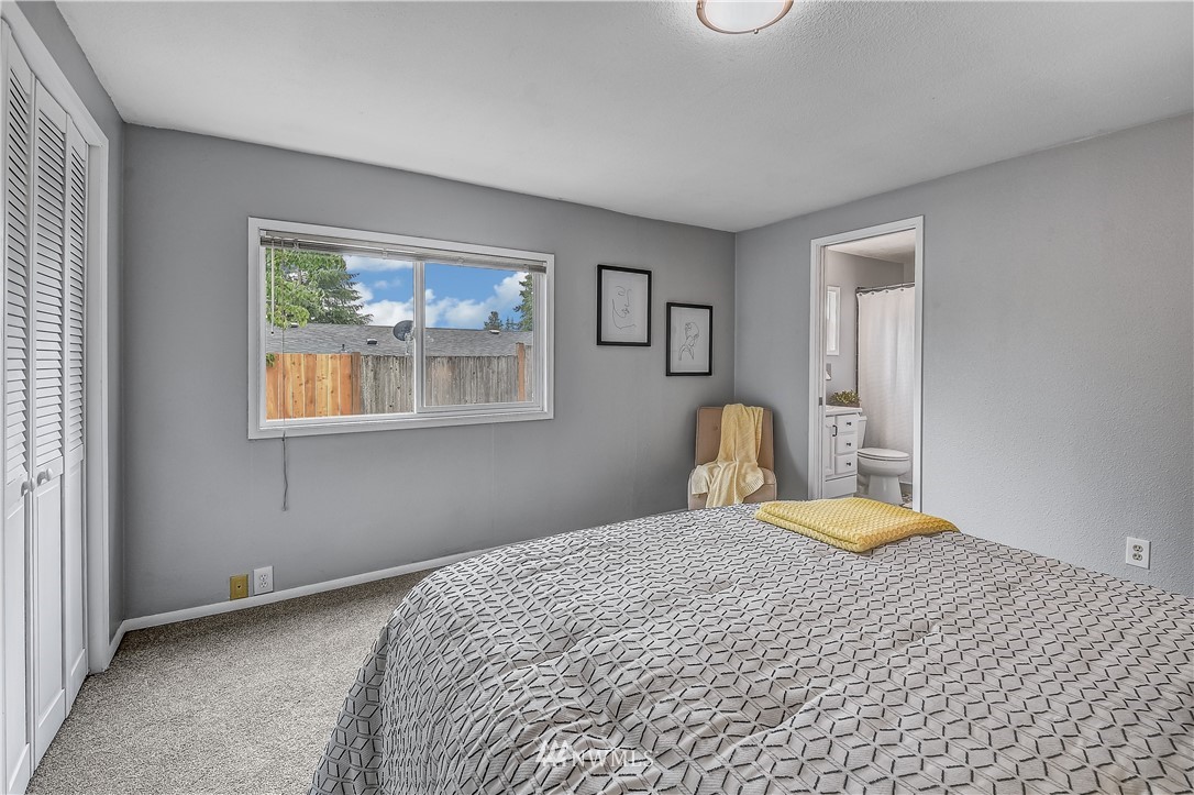 12723 Northeast 199th Street Bothell, WA 98011 - Photo 19 of 34 a bedroom with a bed and a painting on the wall
