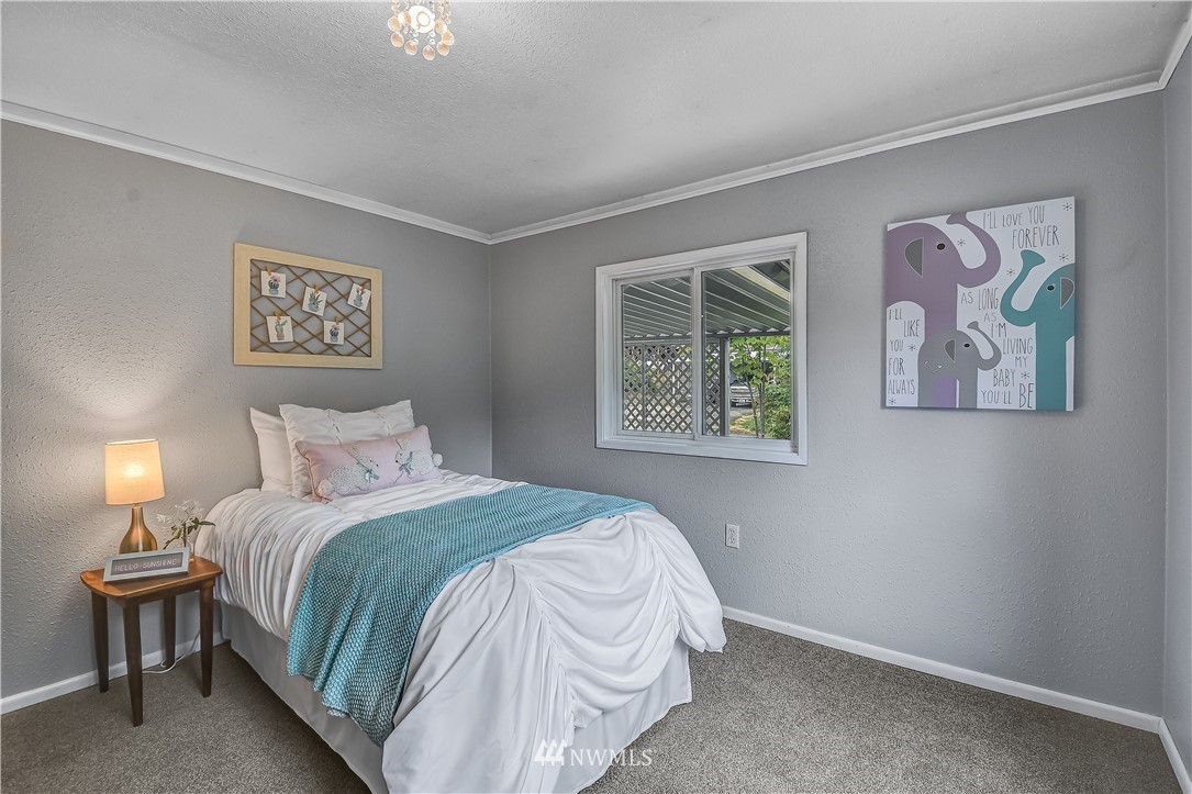12723 Northeast 199th Street Bothell, WA 98011 - Photo 23 of 34 a bedroom with a bed and a painting on the wall