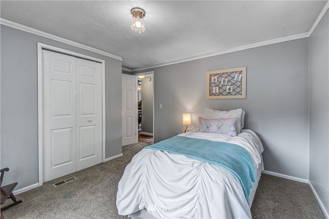 12723 Northeast 199th Street Bothell, WA 98011 - Photo 24 of 34 a bedroom with a bed and a painting on the wall