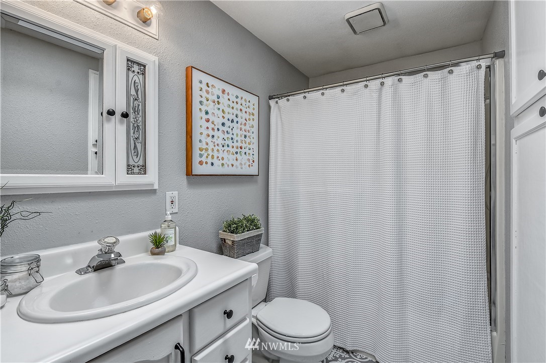 12723 Northeast 199th Street Bothell, WA 98011 - Photo 25 of 34 a bathroom with a sink toilet and mirror