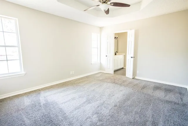 an empty room with a ceiling fan and window