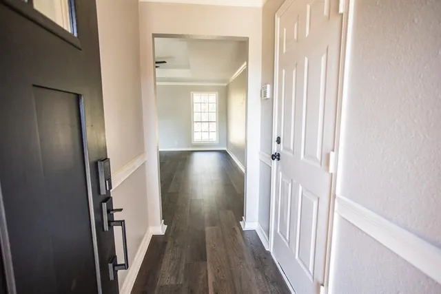 a view of a hallway with wooden floor and staircase