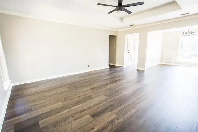 a view of a room with wooden floor and a ceiling fan